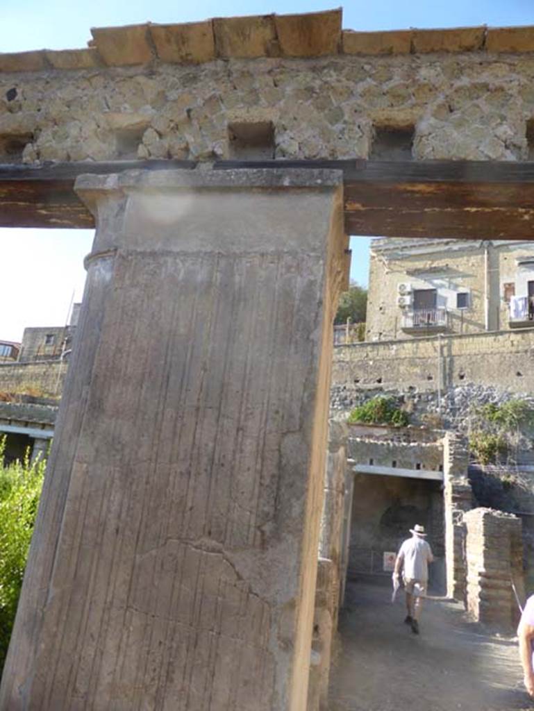 II.2 Herculaneum, September 2015. Upper stuccoed pilaster on north-east corner of peristyle. The holes for the support beams for the floor of the upper rooms can be seen above the pilaster. Looking west along the north portico.
